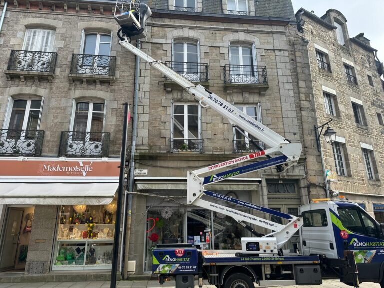 Deux camions nacelle de l'entreprise Réno Habitat stationnés rue commerçante à Saint-Brieuc pendant des travaux de toiture et de zinguerie.
