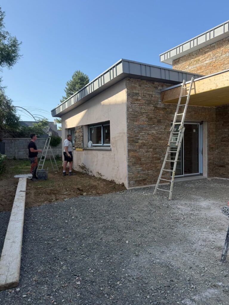 Équipe Réno Habitat sur un chantier d'extension de maison avec couverture en zinc à faible pente dans les Côtes-d'Armor.