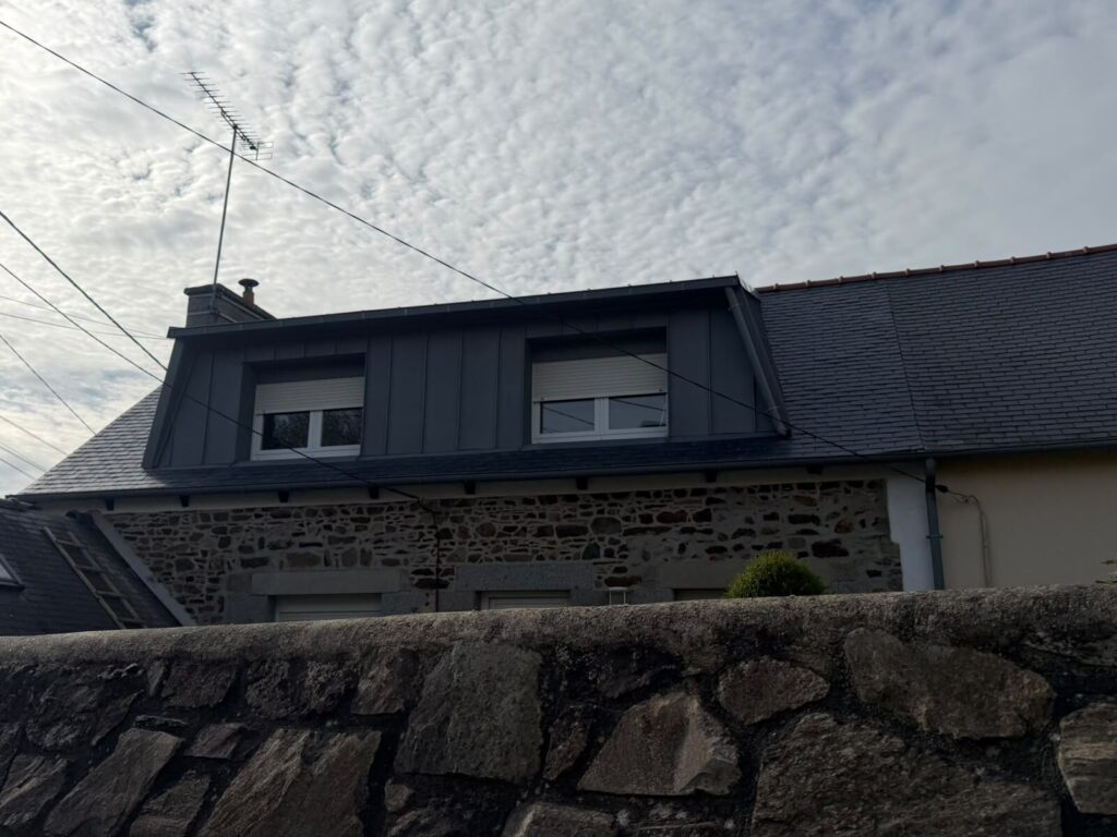 Chien-assis habillé en zinc anthracite à joint debout posé par Réno Habitat sur une maison traditionnelle en pierre des Côtes-d'Armor.