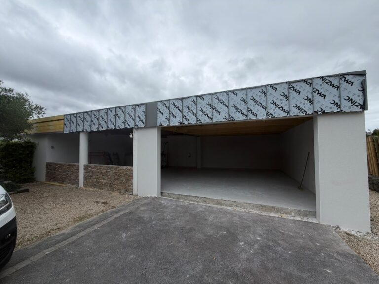 Chantier de couverture en zinc à joint debout sur un carport et un garage, réalisé par les zingueurs de Réno Habitat près de Saint-Brieuc.