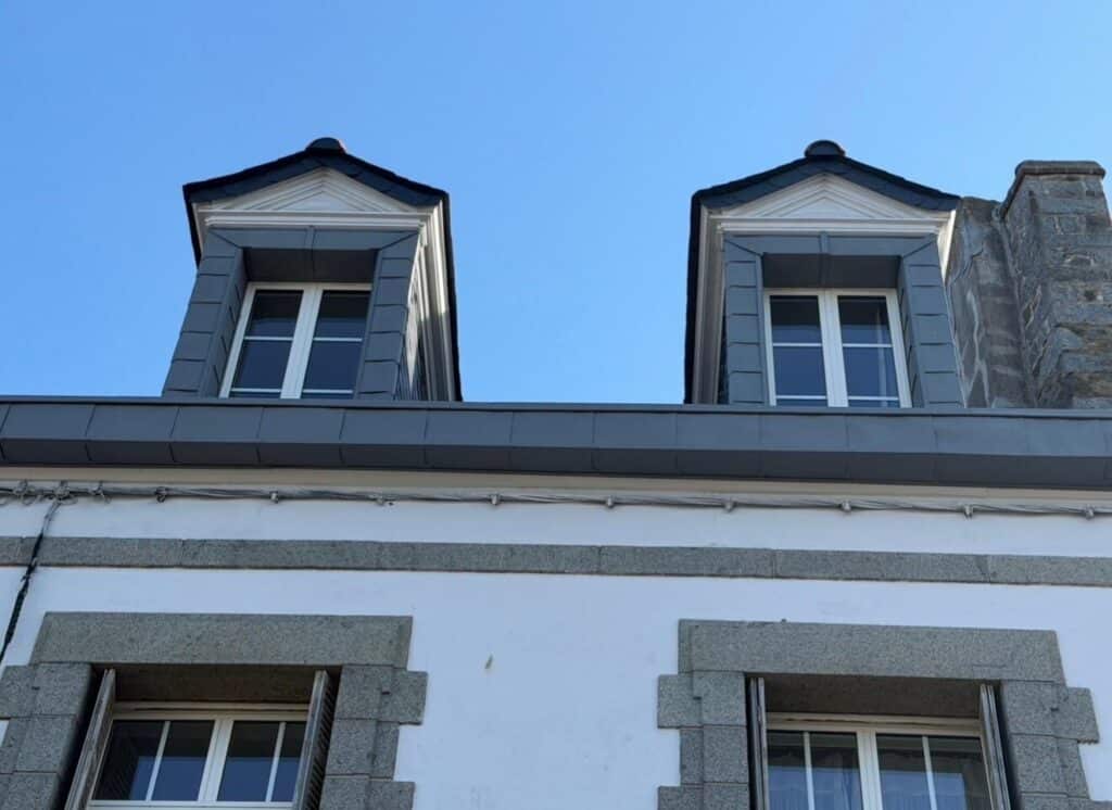 Façade briochine avec deux lucarnes rénovées en ardoise, zinguerie et gouttière neuve, chantier Réno Habitat à Saint-Brieuc.