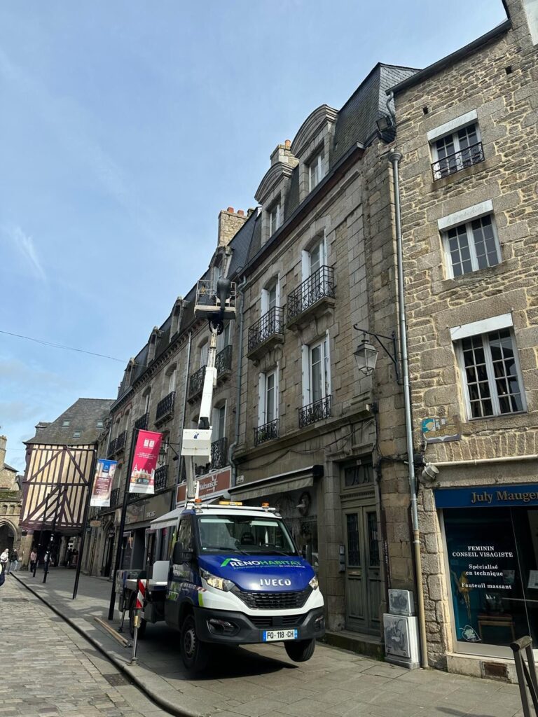 Nacelle élévatrice Réno Habitat dans une rue du centre historique de Saint-Brieuc, près des maisons à pans de bois, pour une intervention de couverture.